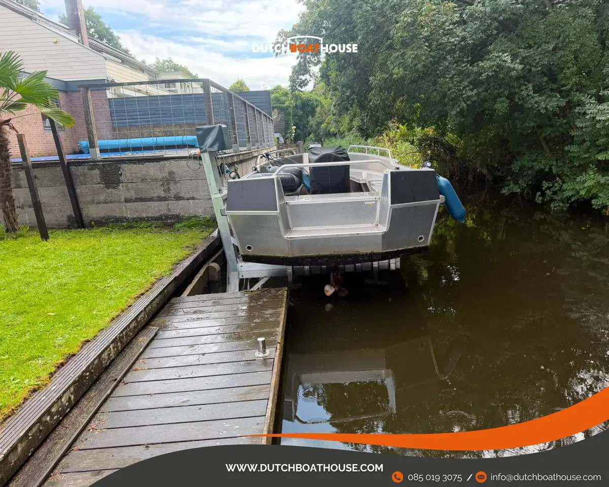 Aluminium boot op een kadelift aan een tuin met steiger in Heemstede