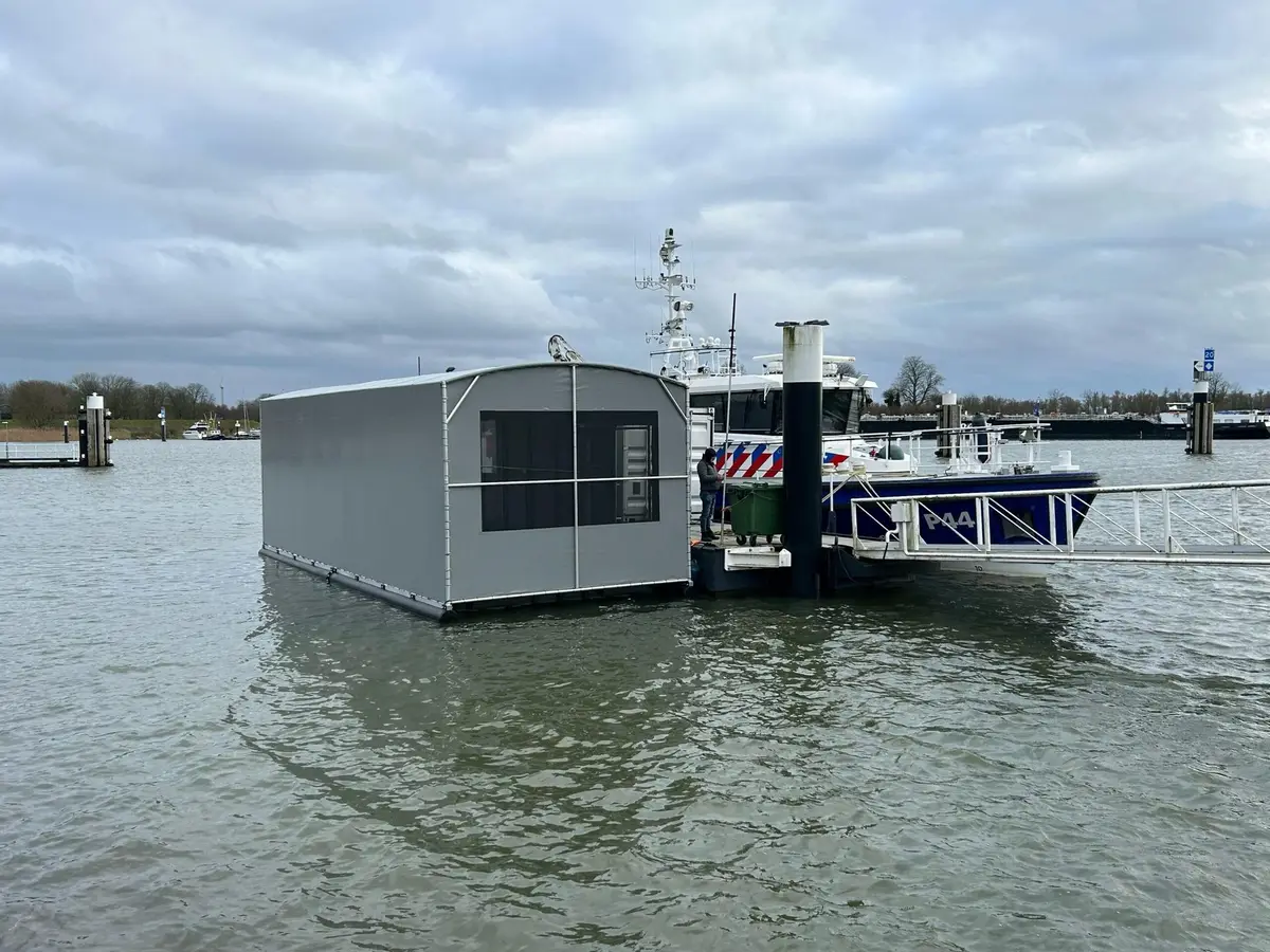 Grijze bootoverkapping op drijvers naast een boot van de politie in Gorinchem